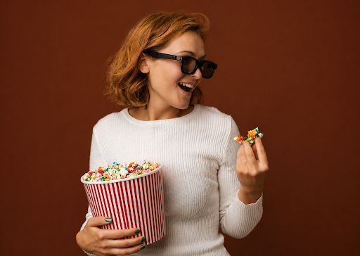 Person enjoying THC popcorn and getting ready for a movie night.