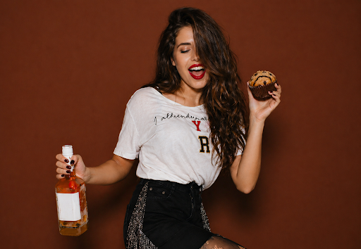 Person holding alcohol and an edible, illustrating mixing edibles and alcohol and the effects of cross-fading.
